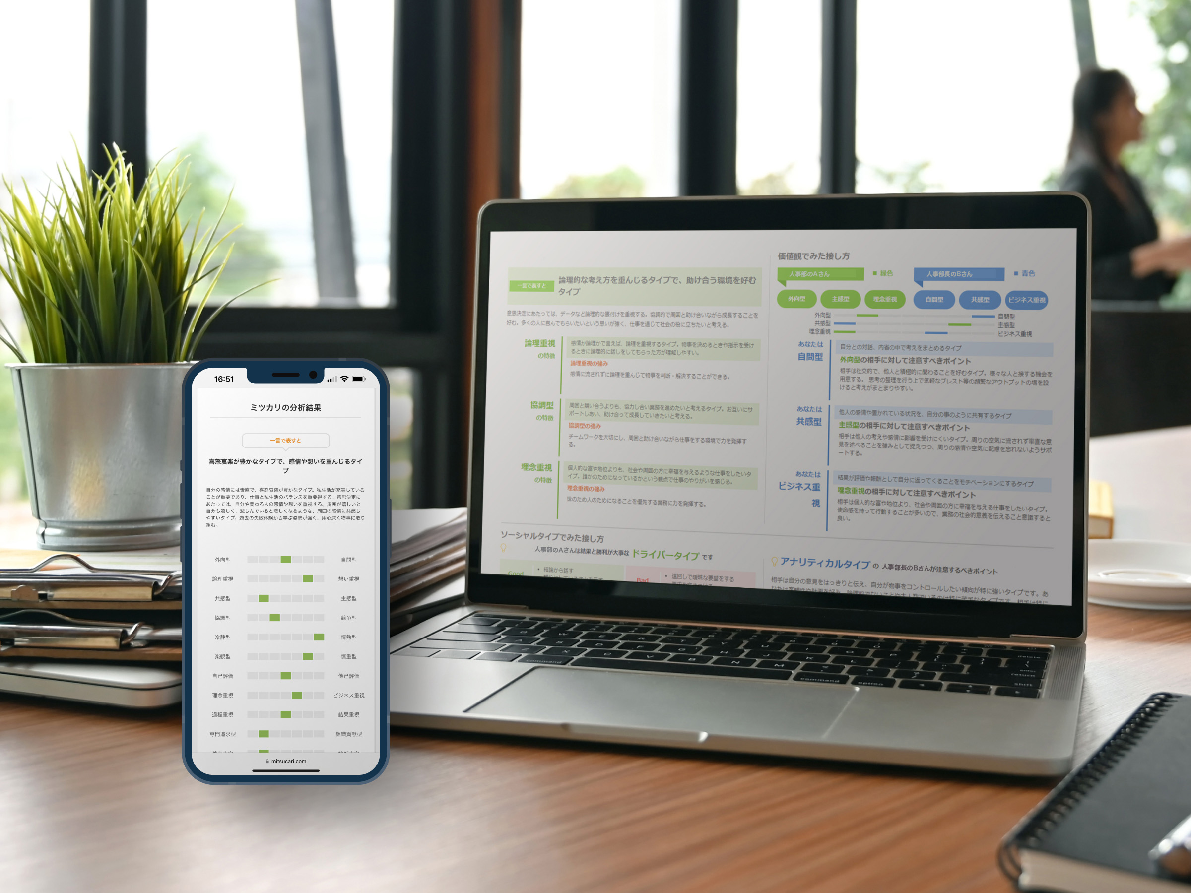 机の上にパソコンとスマホがありミツカリの分析結果が表示されている